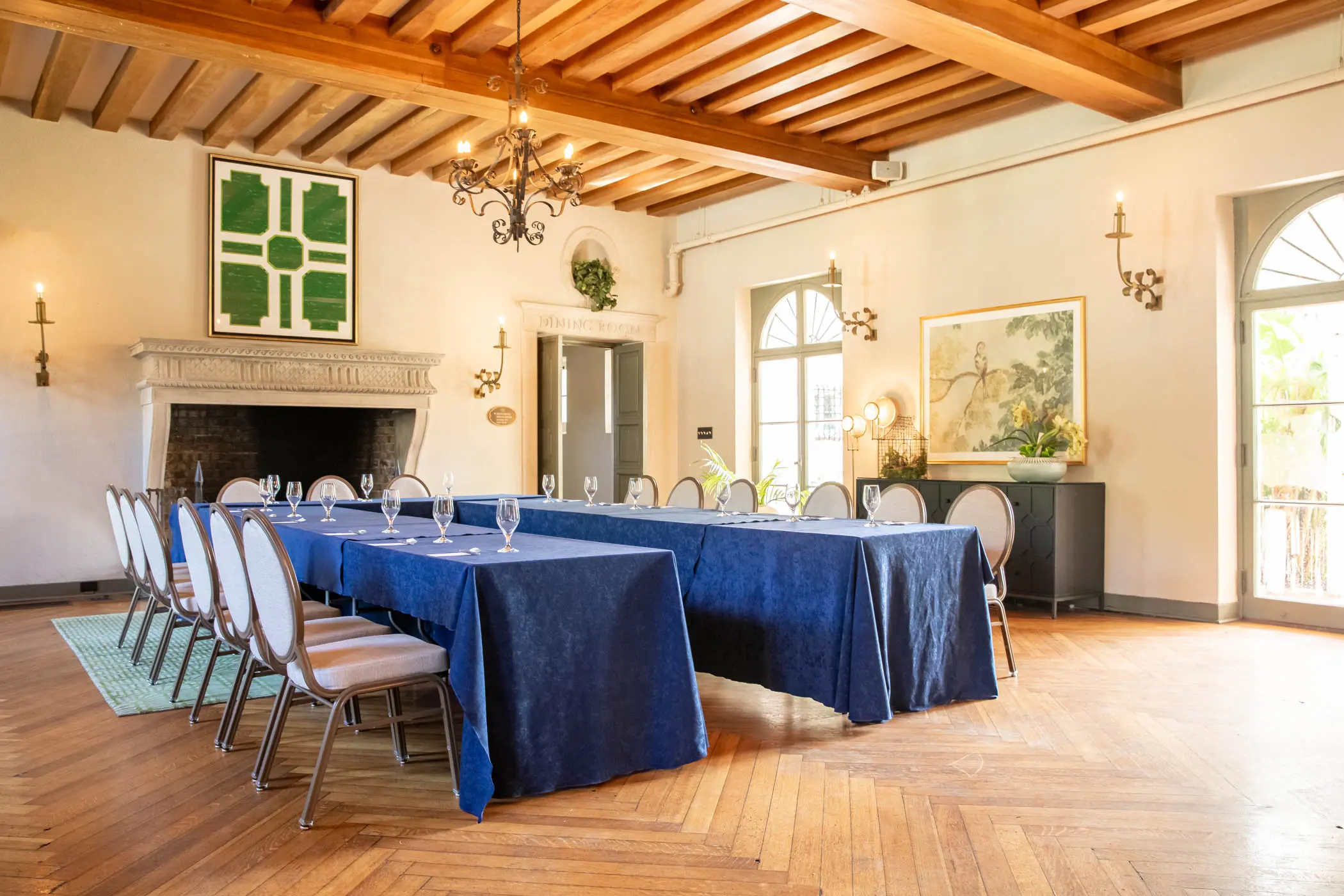 A space set up for a function with 2 long tables set with glasses and silverware